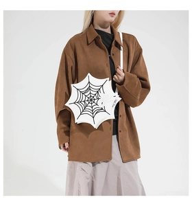 Close-up of white PU leather crossbody bag with black spider web pattern and spider charm