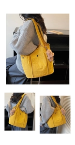 Detail of yellow canvas tote bag with deep snap pockets and a cute bear keychain