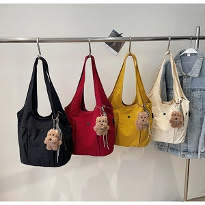 Detail view of large nylon shoulder bags in four colors with cute puppy charms