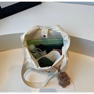 Top view of spacious cream tote bag showing organized interior with tablet and umbrella