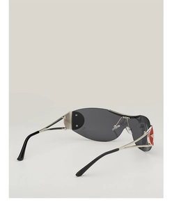 Detail of silver Y2K pilot sunglasses featuring a red star accent on the temple hinge