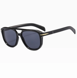 Detail view of large frame sunglasses with black glossy finish and gold arrow hardware