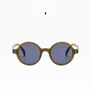Détail de lunettes de soleil rondes rétro vert gelée avec verres fumés et rivets métalliques