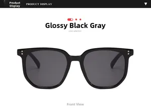 Front view of shiny black oversized sunglasses with grey lenses and silver studs