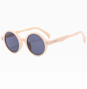 Détail de lunettes de soleil rondes beiges pour enfants avec branches ondulées
