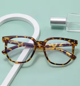 Flat lay of tortoiseshell frame glasses with metal rivets on a mint green background