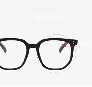 Close-up of black oversized square glasses frames with silver rivet detail and blue light lens