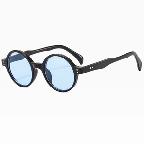 Gros plan de lunettes de soleil rondes vintage noires avec verres bleu clair et rivets