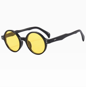 Détail de lunettes de soleil rondes rétro avec monture noire et verres jaunes
