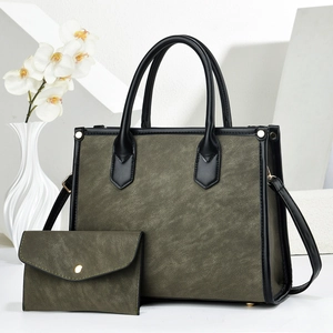 Olive green tote bag set with pebble grain leather and gold studs on display stand