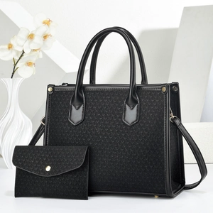 Detail der schwarzen Strick-Einkaufstasche und passenden kleinen Umschlagtasche mit Goldnieten
