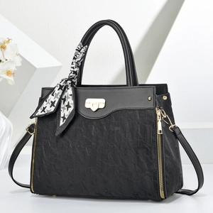 Large black leather shoulder bag with woven texture and decorative silk scarf detail