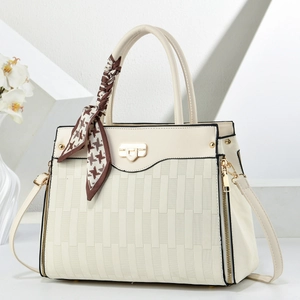 Close-up of cream textured faux leather bag with elegant houndstooth scarf handle detail