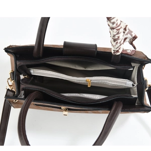 Macro detail of brown leather handbag interior with three zip compartments and silk scarf