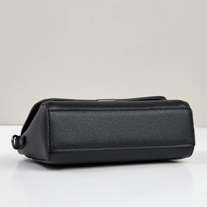 Detail of black lychee grain leather bag with refined stitching and dark metal buckle hardware