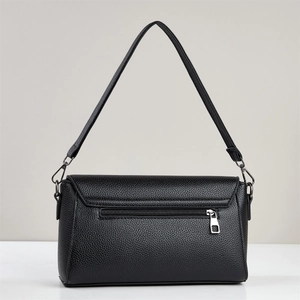 Close-up of black lychee grain leather shoulder bag with back zipper pocket and silver hardware