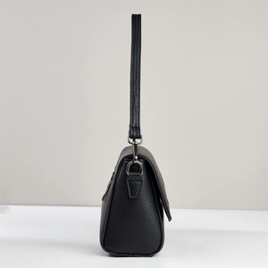 Side profile of a black lychee texture leather shoulder bag with sleek silver hardware