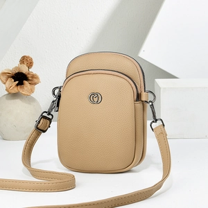 Brown lychee leather crossbody bag with dual zippers and circular hardware detail