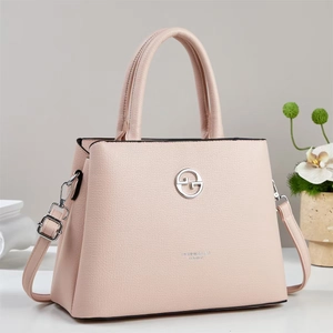 Dettaglio borsa rosa in pelle litchi con logo argento e tracolla regolabile rimovibile