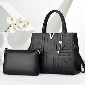 Detail of two-piece tote bag set with black crocodile texture and golden V hardware