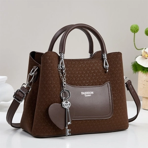 Close-up of brown tote bag with woven texture, metal heart and key charms