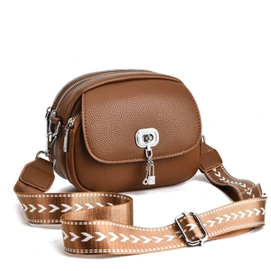 Brown lychee leather crossbody bag with silver hardware and patterned wide strap