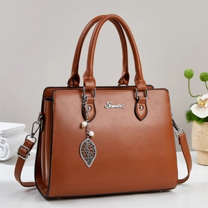 Elegant caramel brown structured handbag with pearl charm and detachable shoulder strap