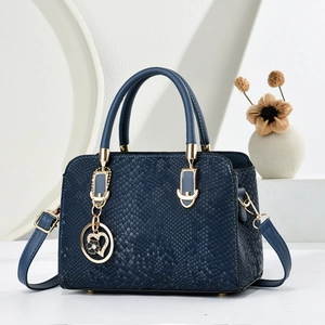 Navy blue snake embossed crossbody handbag with gold hardware and floral charm pendant