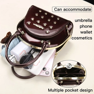 Macro view of large wine red patent leather tote bag with rivets showing spacious interior