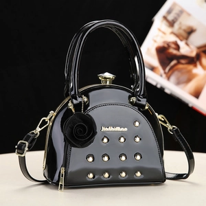 Elegant black patent leather handbag with gold rivets and 3D floral charm detail