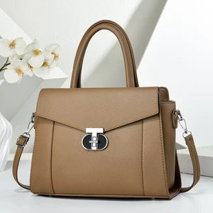 Detailed shot of brown pebble leather handbag with silver geometric twist lock closure
