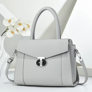 Detailed macro view of litchi textured leather handbag with metallic geometric lock