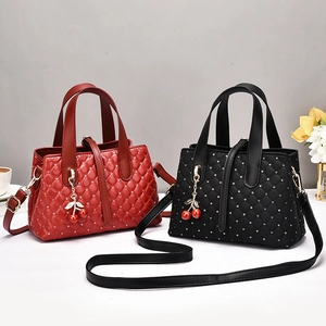 Macro shot of quilted leather handbags in burgundy and black with rivet details