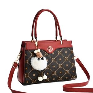 Red-brown leather and monogram canvas crossbody tote bag with a cute plush charm