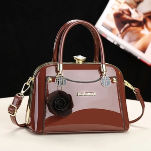 Elegant brown patent leather handbag for women featuring a glossy finish and gold metal accents