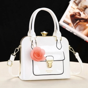 Elegante borsa a mano in vernice bianca con finiture dorate e ciondolo a rosa rosa