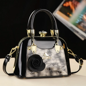 Sac bandoulière chic en cuir verni noir avec accent floral et empiècement animal