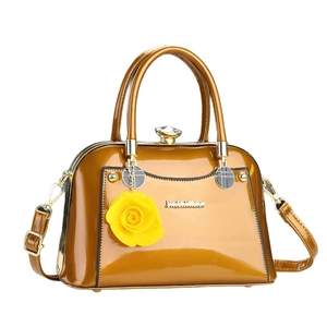 Elegant bronze patent leather handbag with floral pendant and adjustable shoulder strap