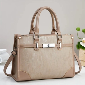 Detail of minimalist tote bag with two-tone panels, striped texture and silver metal lock