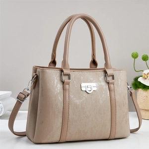 Dettaglio borsa a mano con trama elegante, chiusura argentata e tracolla in pelle