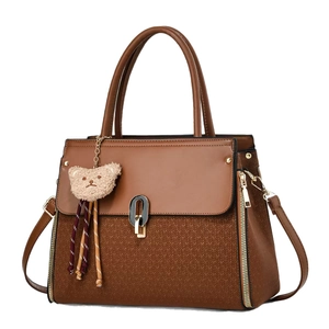 Brown vintage handbag with woven texture and teddy bear charm on white background