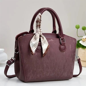 Close-up of burgundy retro handbag with ribbed texture and striped silk scarf detail