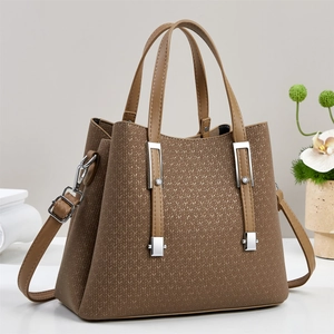 Close-up of brown trapezoid handbag featuring V-shaped knit texture and golden shimmer