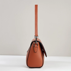Dettaglio borsa a tracolla in pelle martellata color cuoio con gancio in metallo scuro