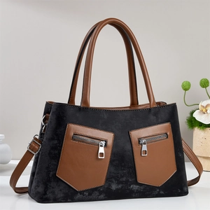 Detailed view of the retro contrast color handbag featuring black suede and brown leather