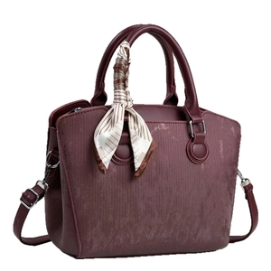 Burgundy corduroy handbag with striped silk scarf decor and adjustable strap on white background