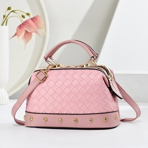 Sac à main rose texture tressée avec détails dorés et poignée dans un décor minimaliste