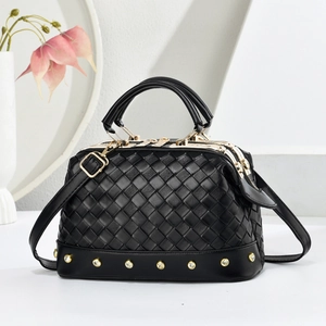 Détail du sac en cuir tressé noir avec clous dorés et finitions métalliques lisses