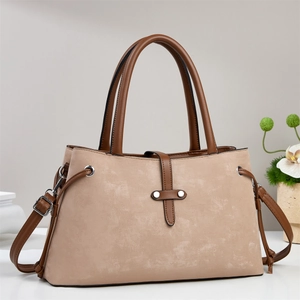 Detail of light beige suede crossbody bag with dark brown leather straps and metal buckle