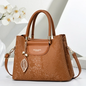 Sac à main marron motif serpent avec pendentif feuille dorée et bandoulière réglable